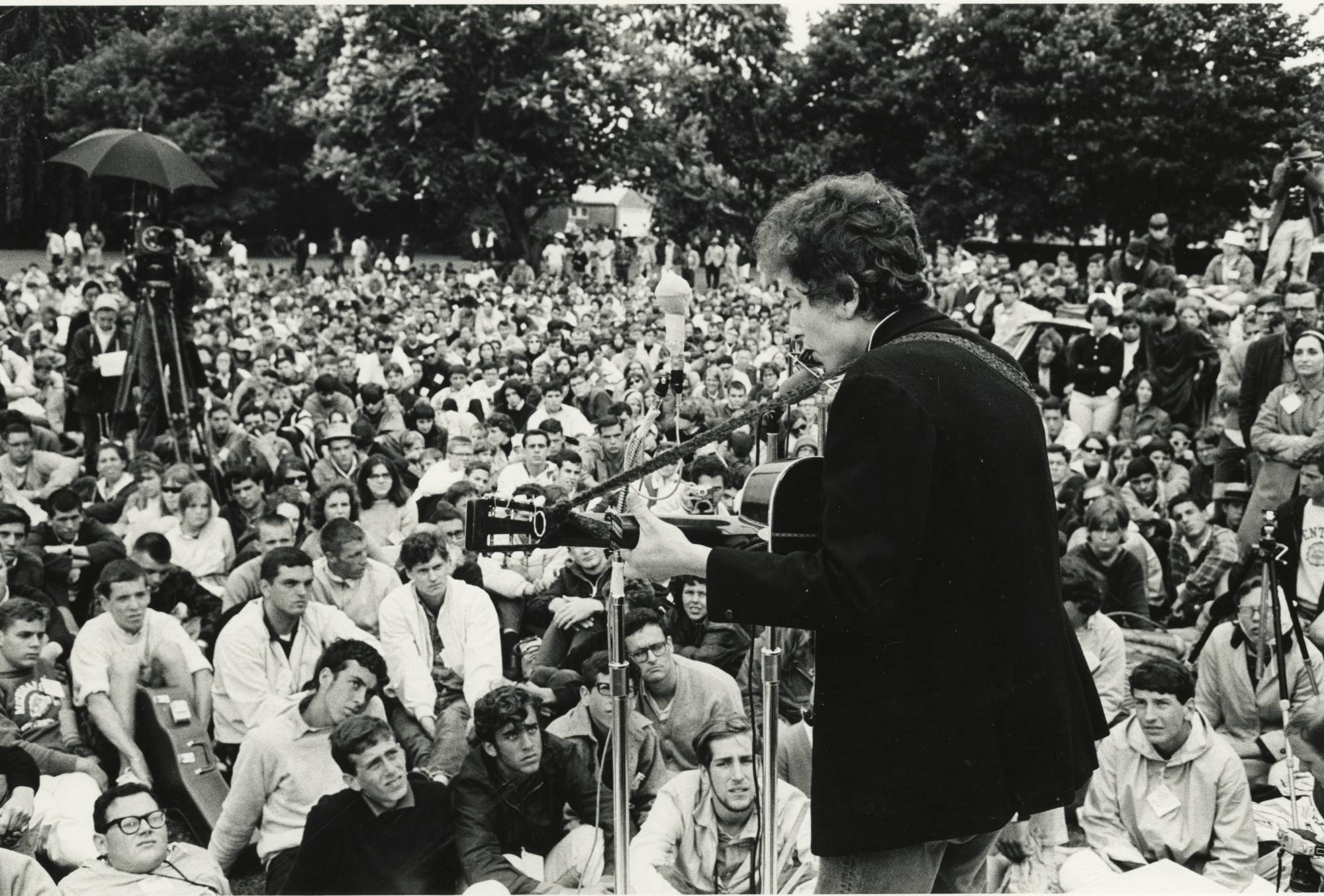 Bob Dylan on stage playing guitar and singing to crowd